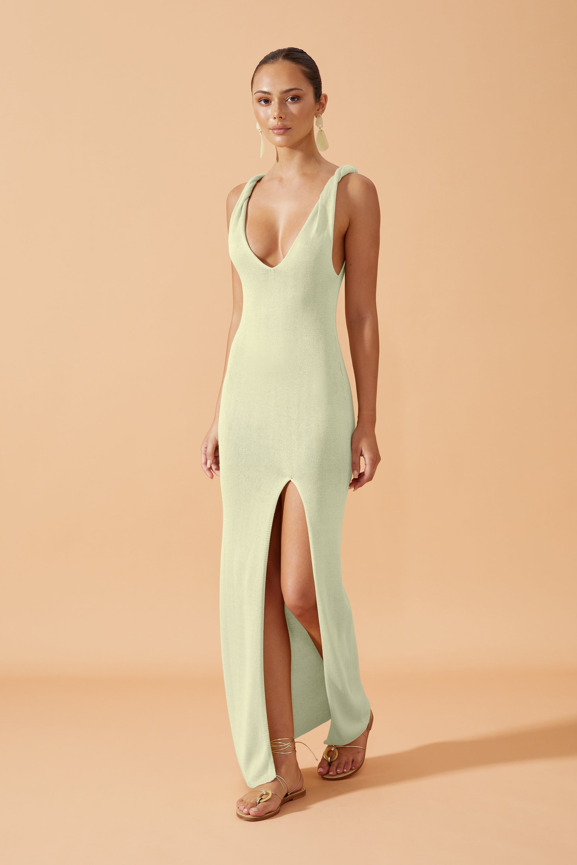Flook The Label Anaya  Knit Long Dress with side slit in  Pistachio,  worn with drop earrings  front view