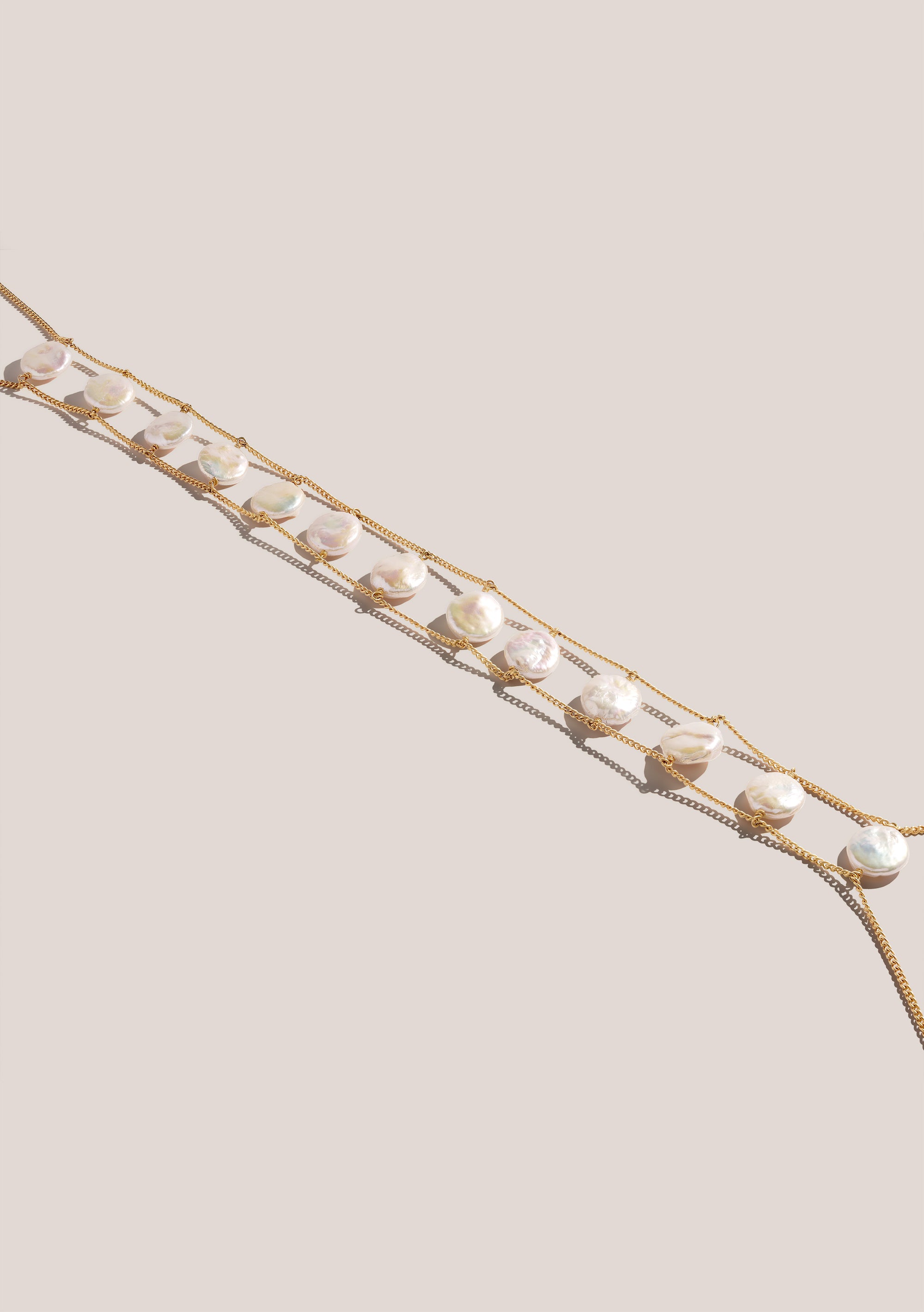 Pearl bodychain against a beige background