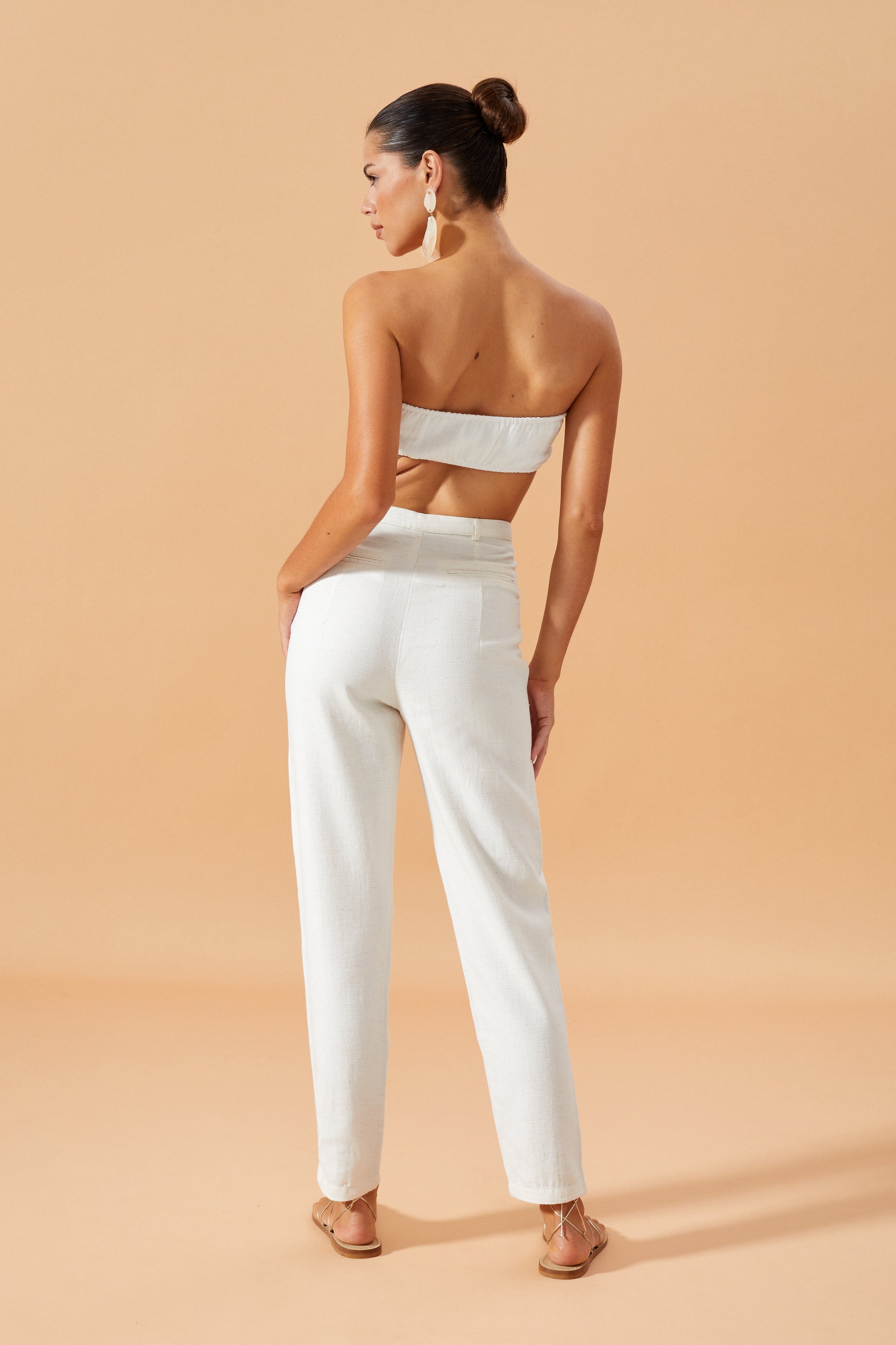 Back image of the Shania bralette Top in Off White featuring a centre knot design, styled with Vietta Pants