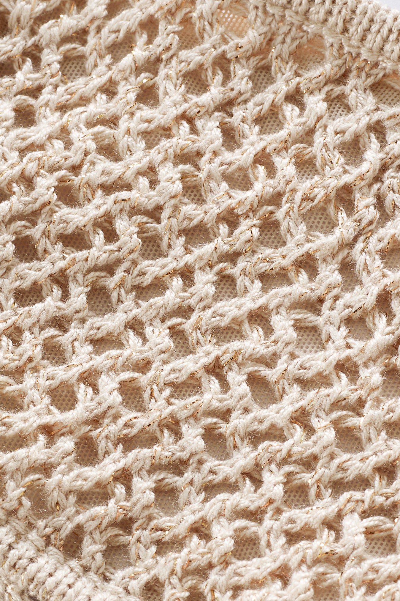 Close-up of the Isela Bandeau Top in beige, featuring open-weave crochet with a textured crisscross pattern and visible yarn loops for a lacy, airy look.